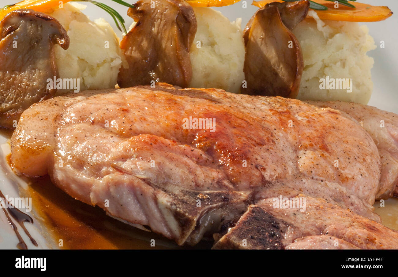 Gebratene Schweineschnitzel garniert mit gestampften Kartoffeln und Champignons Stockfoto