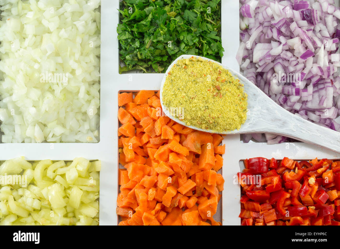 Weiße Holzlöffel mit Würze auf die bunten Gewürzen, Gemüse und Zutaten auf eine rechteckig geformte Pla bestellt Stockfoto