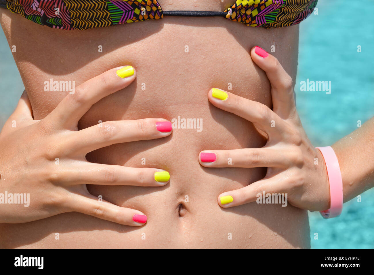 Mädchen im Bikini messen Taille mit den Händen am Meer Stockfoto