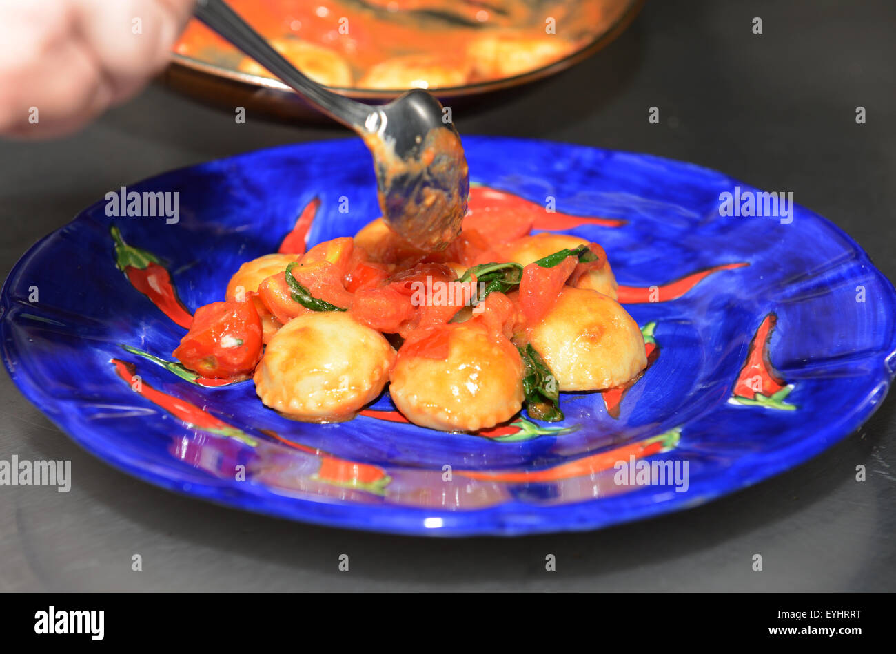 Ravioli mit San Marzano-Tomaten-Soße gekocht und fesch Basilikum Blätter. Stockfoto
