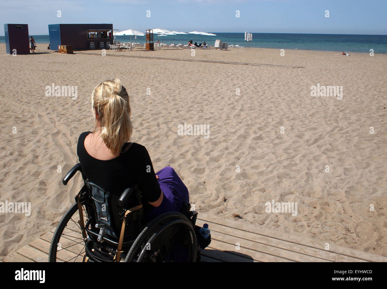 Frau in einem Rollstuhl, genießen einen sonnigen Nachmittag am Strand Stockfoto