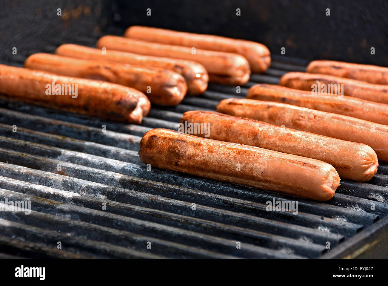 Reihe von Rindfleisch Hotdogs Kochen auf ein Barbecue-Grill. Stockfoto