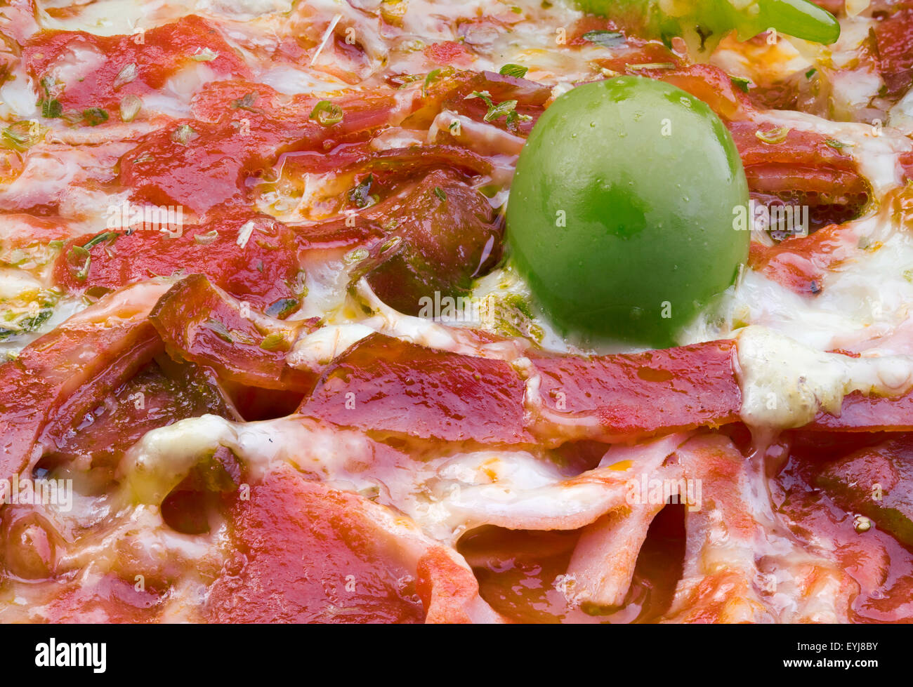Nahaufnahme Makro Speck Pizza Detail mit Olive Stockfoto