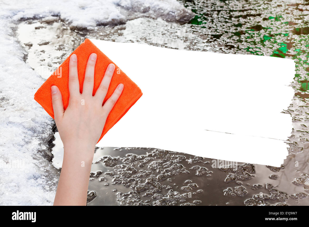 Wetter-Konzept - Hand löscht Schneeschmelze durch orange Lappen aus Bild und weißem leeren textfreiraum erscheinen Stockfoto