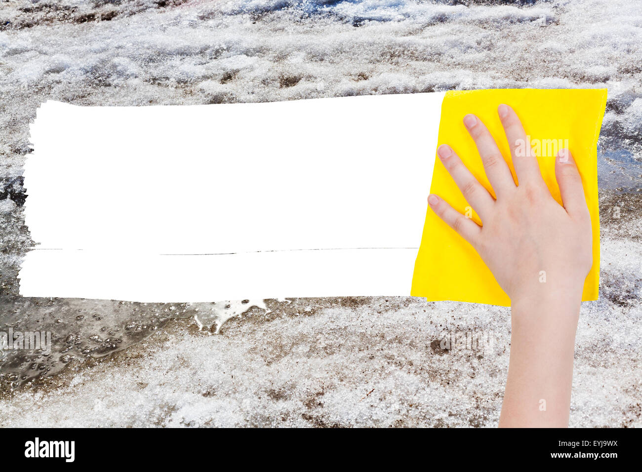 Wetter-Konzept - Hand löscht Schneeschmelze durch gelbe Lappen aus Bild und weißem leeren textfreiraum erscheinen Stockfoto