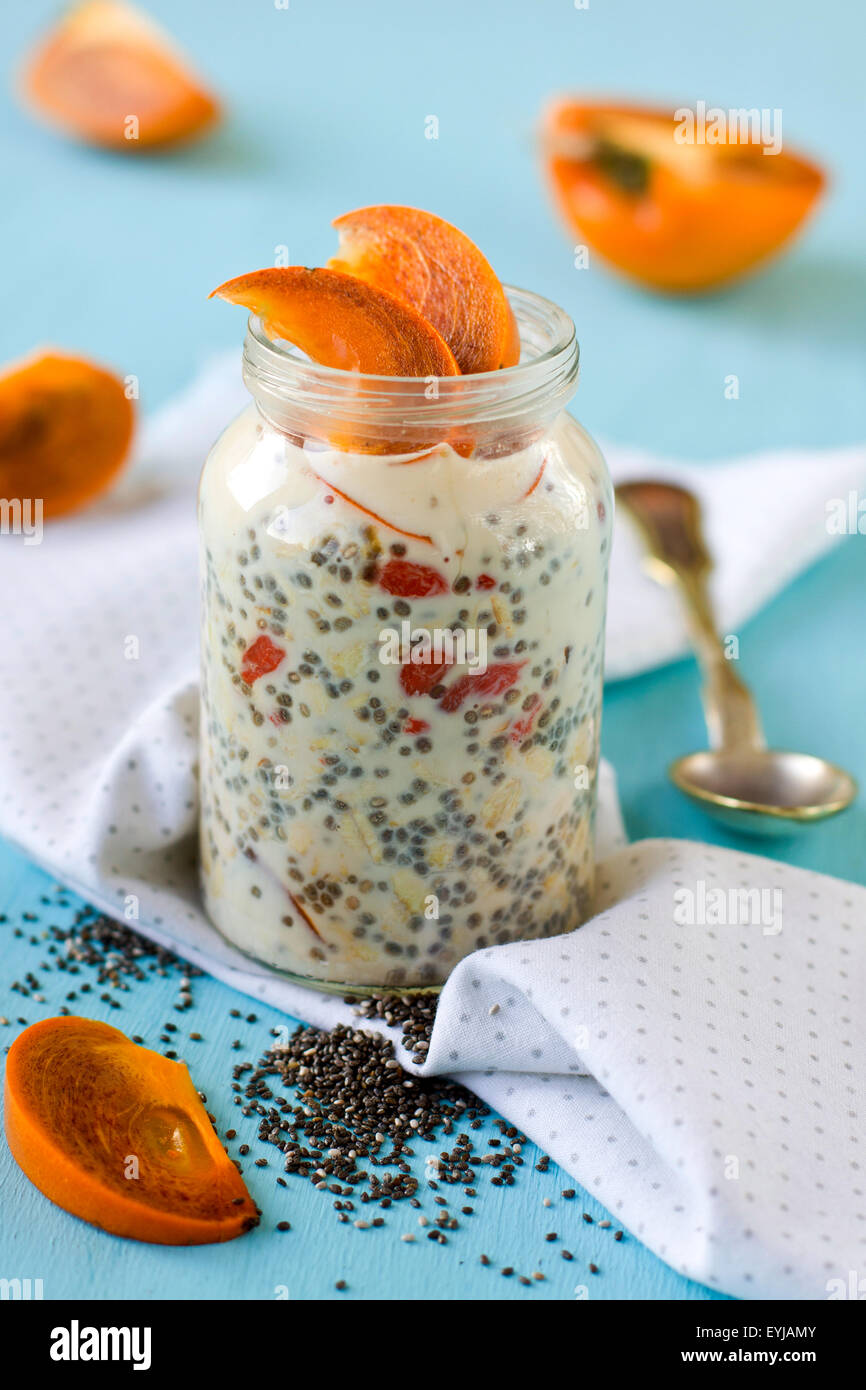 Joghurt mit Chiasamen und Goji-Beeren serviert mit geschnittenen Kaki Stockfoto