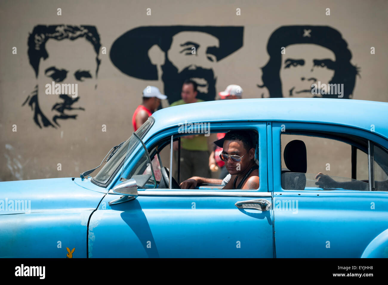 Havanna, Kuba - Juni 2011: Fußgänger und klassischen amerikanischen Autos passieren vor Schablone Plakatwand mit kommunistischen Führer. Stockfoto