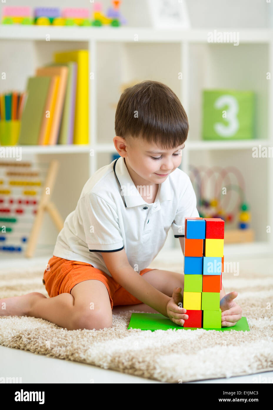 Kind kleinen Jungen spielen mit Würfeln, Lächeln Stockfoto