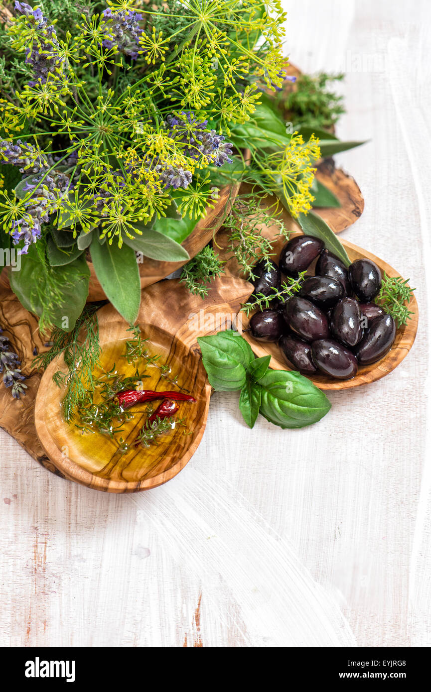 Oliven, Öl, Basilikum, Dill, Salbei, Lavendel. Kräuter und Gewürze über rustikalen hölzernen Hintergrund. Gesunde Ernährung Stockfoto