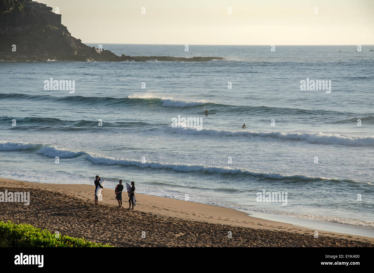 Surfbrettfahrer halten ihre Boards und unterhalten sich am Ufer am Palm Beach in Sydney in Australien Stockfoto