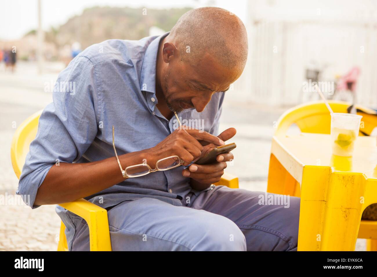 Reifer Mann konzentriert sich auf Smartphone in Bar am Strand von Ipanema, Rio De Janeiro, Brasilien Stockfoto