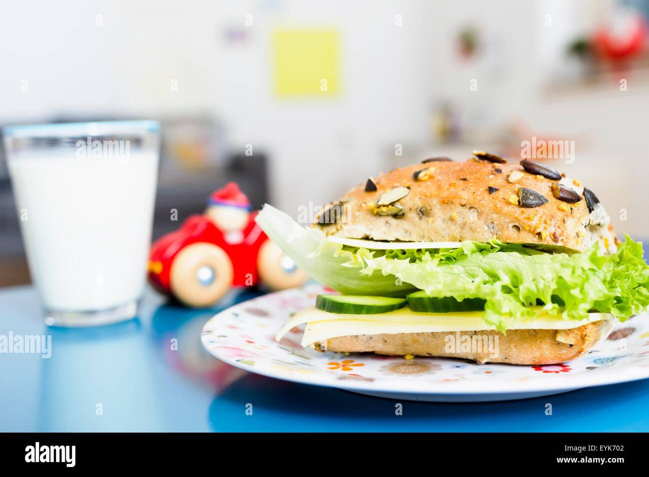 Sandwich, Glas Milch, Spielzeugauto auf Tisch Stockfoto