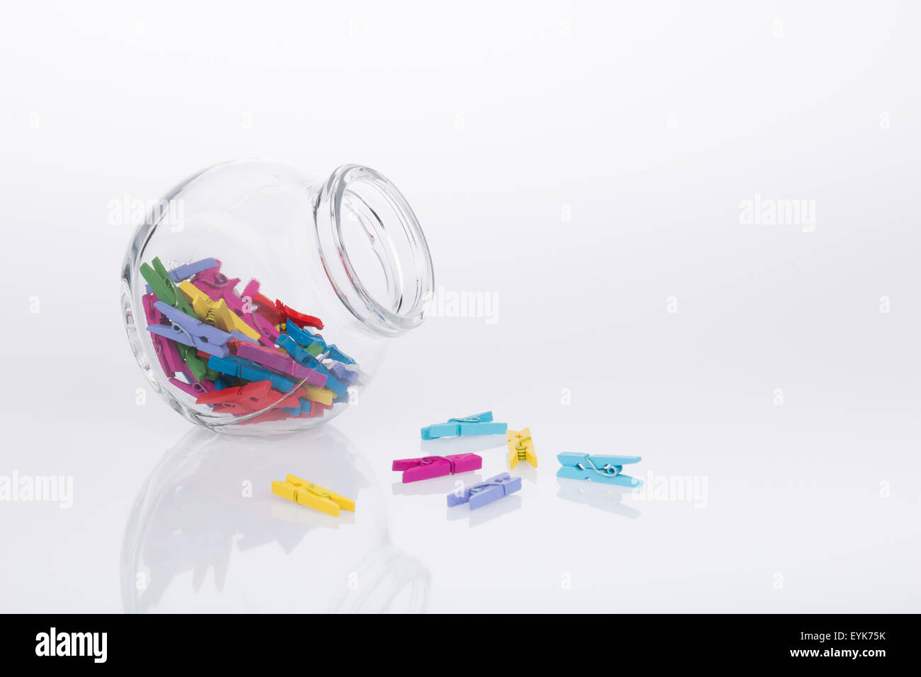 Glas von bunten Miniatur Wäscheklammern auf weißem Hintergrund Stockfoto