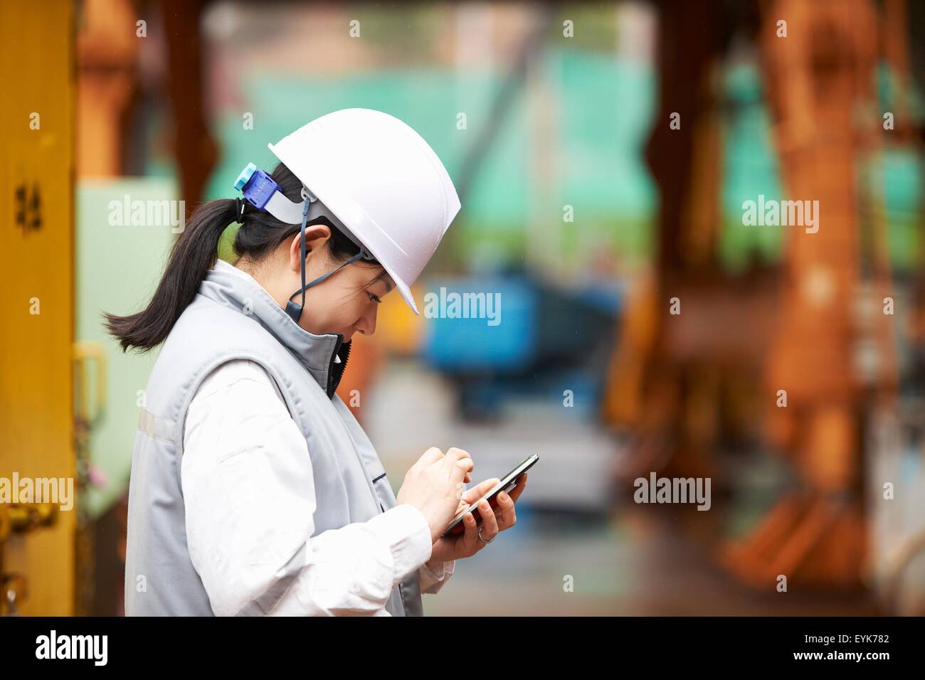 Arbeiter mit Smartphone auf Werft, GoSeong-Gun, Südkorea Stockfoto