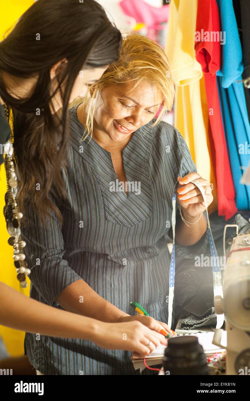 Schneiderin schreiben Kunden Messungen in Näherei Stockfoto