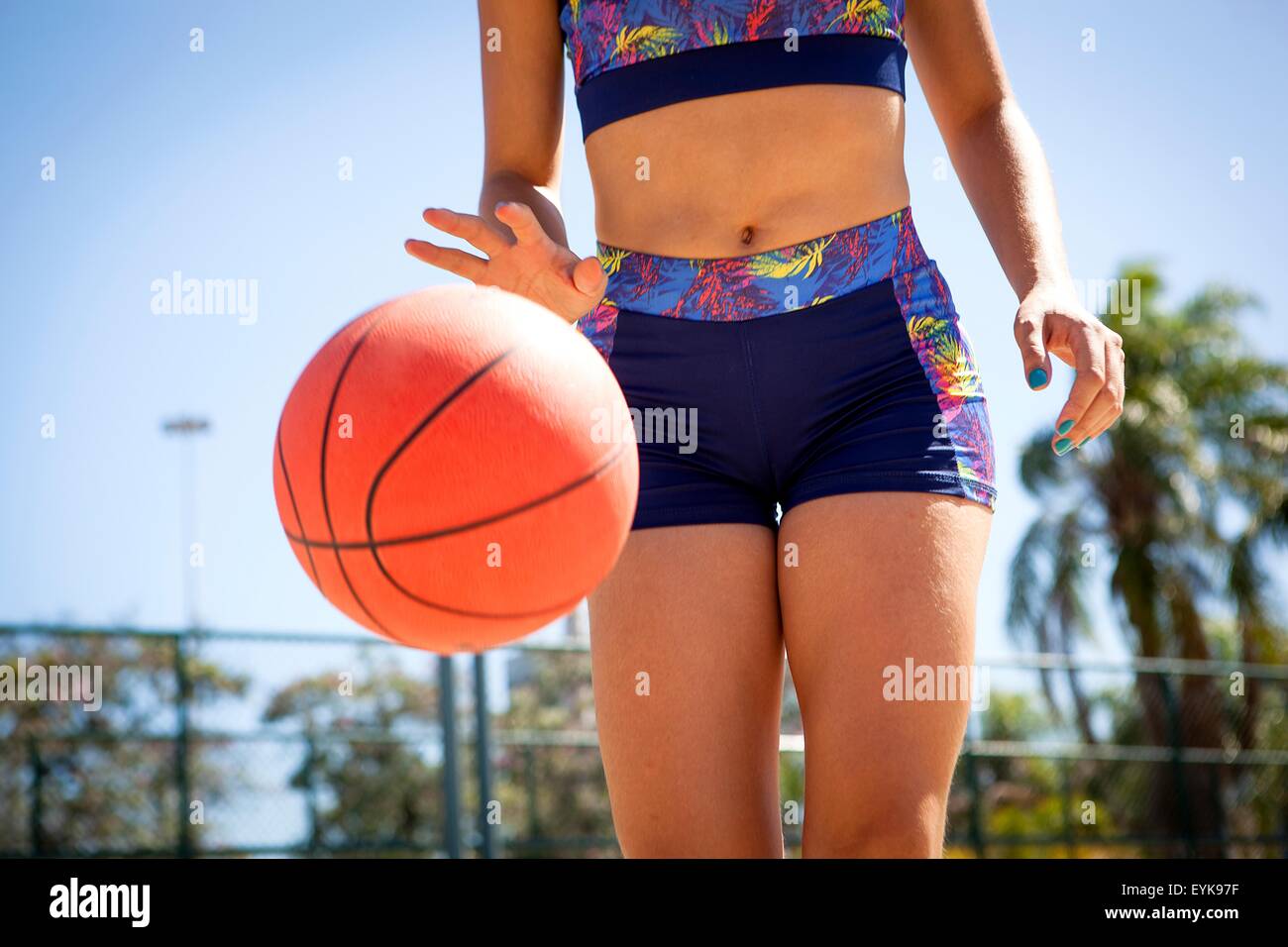 Junge Frau dribbling Basketball, Mittelteil Stockfoto