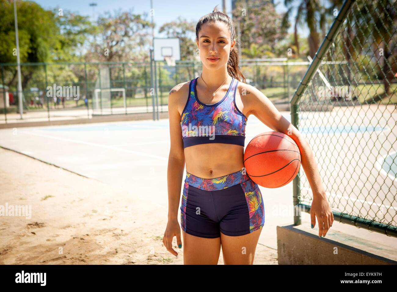 Porträt der jungen Frau mit Basketball unter Arm, im freien Stockfoto