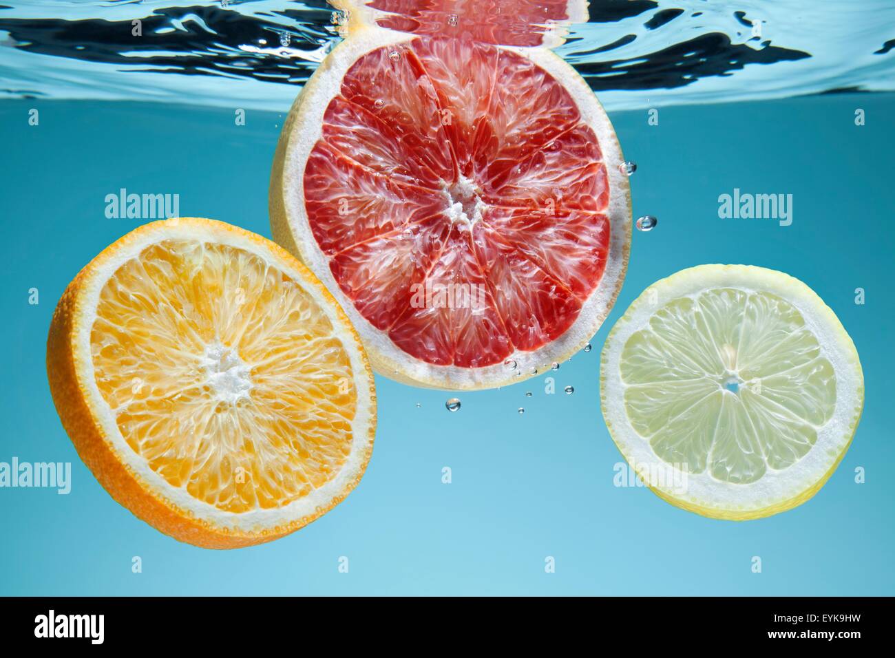 Scheiben von rosa Grapefruit, Orange und Zitrone unter Wasser Stockfoto