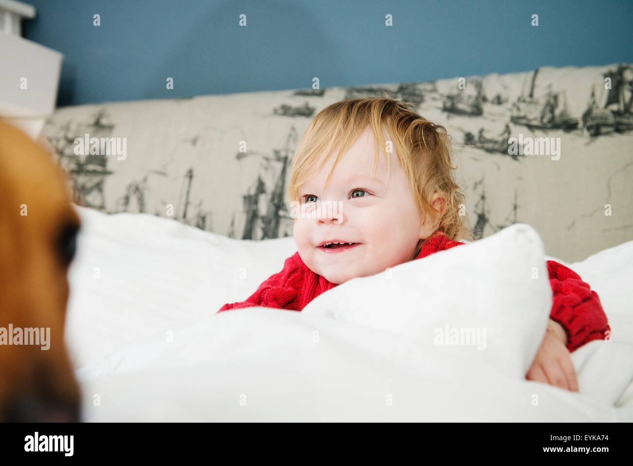 Junge Smiing im Bett Stockfoto