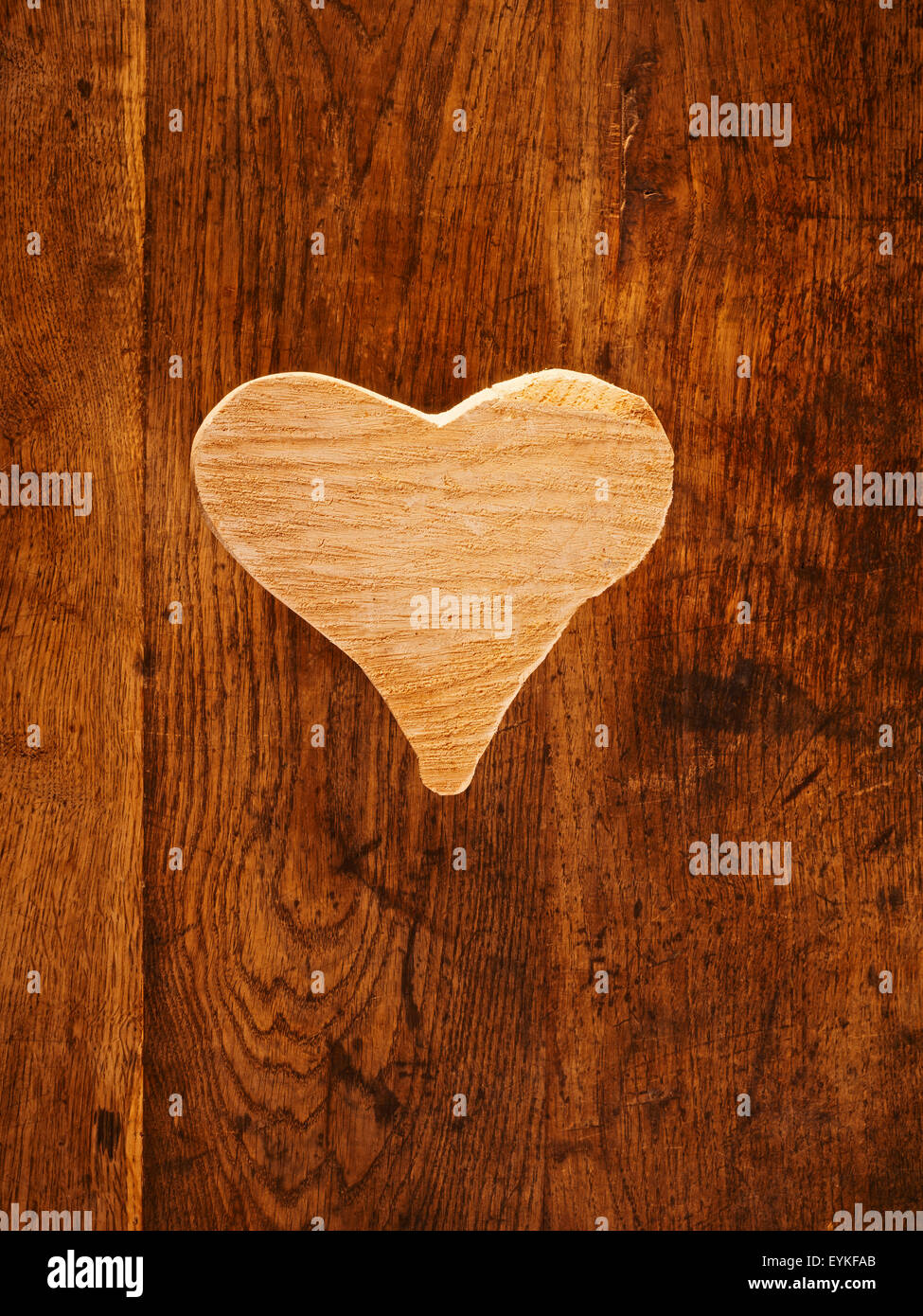 Beige Herz aus Holz auf einem braunen Tisch Stockfoto