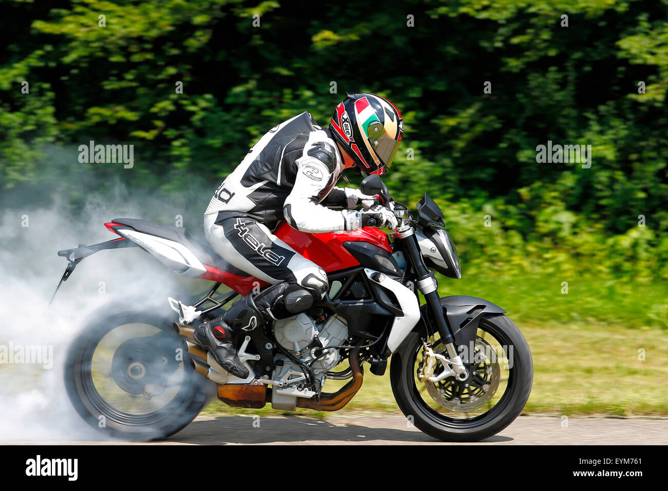 Motorrad, drei-Zylinder-Motor, MV Agusta Brutale 675 Tripistoni, Baujahr 2012, Burnout auf Landstraße, geschwenkt, Rauchen Hinterreifen, Stockfoto