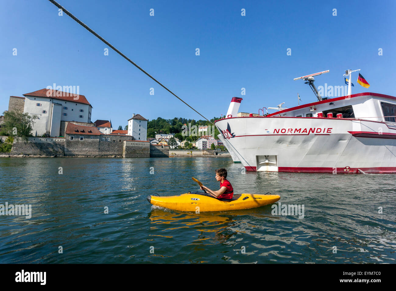 Junge in einem Kajak schwimmend durch Um den Liegeplatz Boot auf der Donau. Passau, Niederbayern, Deutschland Stockfoto