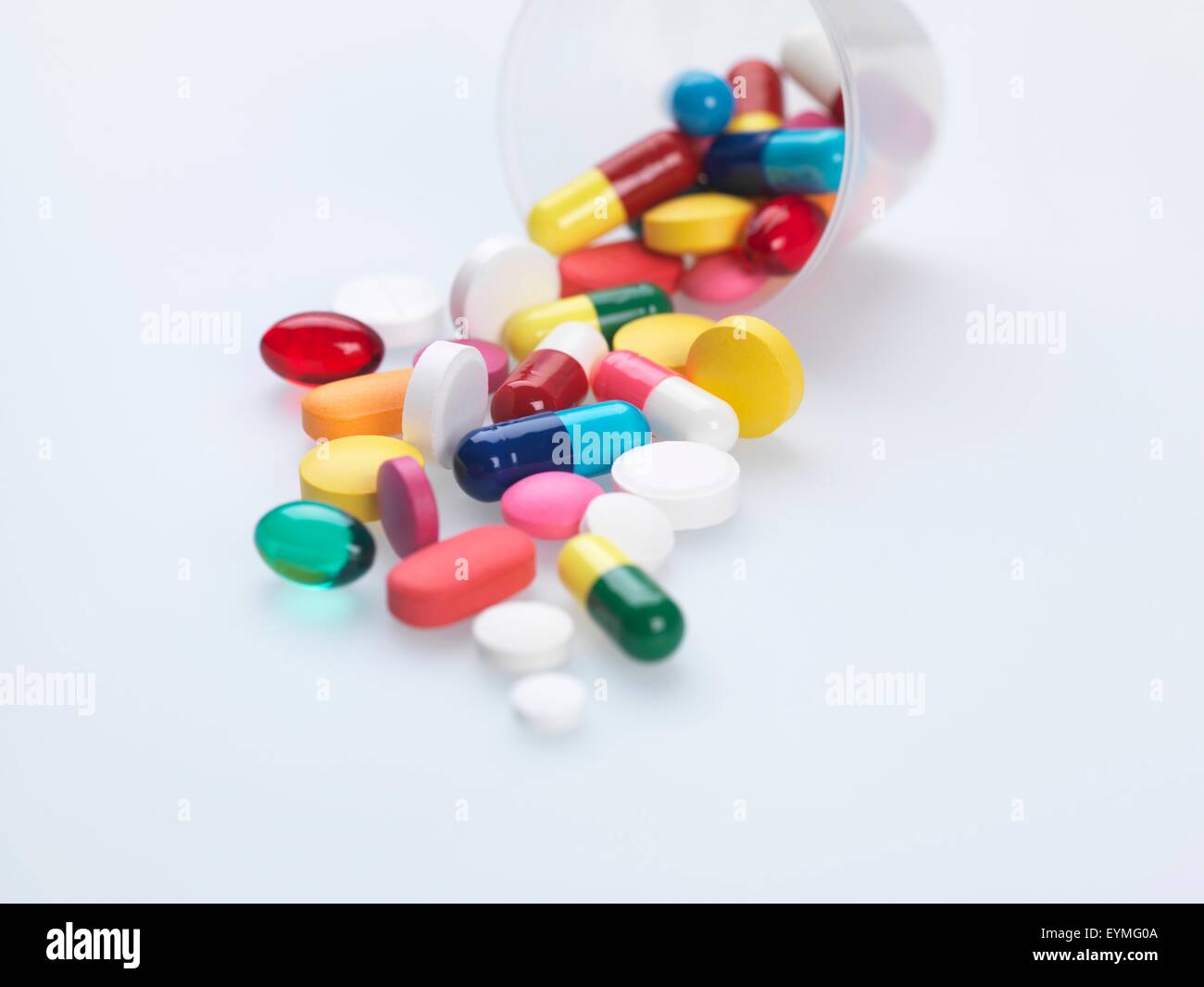 Eine Vielzahl von Pillen aus Kunststoff Messcontainer fallen. Stockfoto