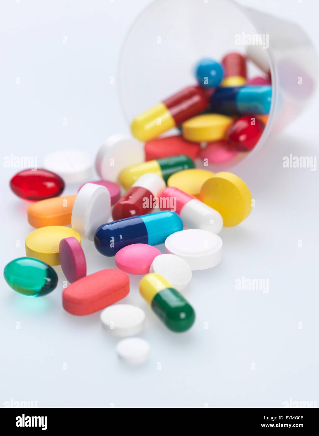 Eine Vielzahl von Pillen aus Kunststoff Messcontainer fallen. Stockfoto