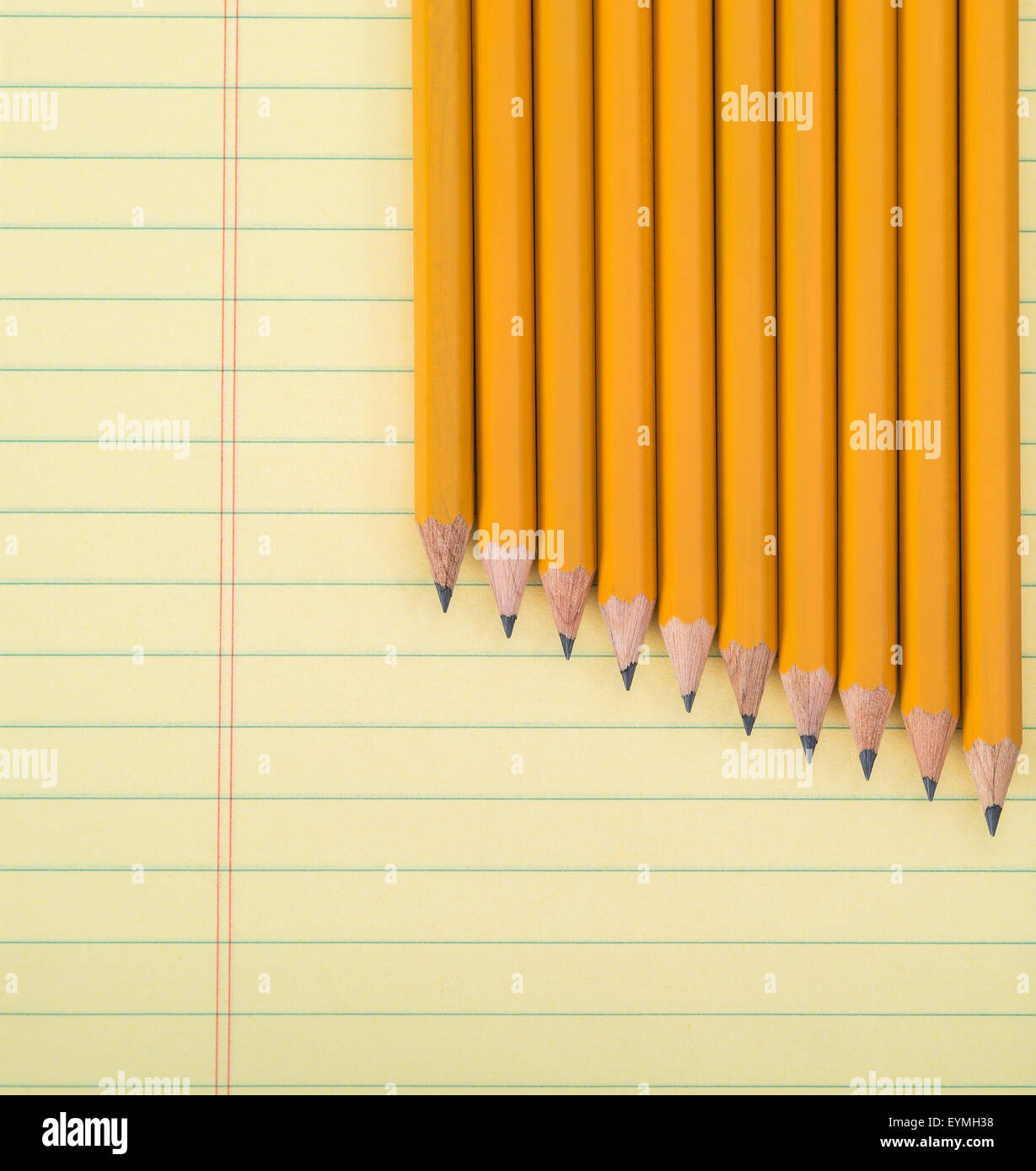 Zeile der gelbe Bleistift gegen einen Notizblock Stockfoto