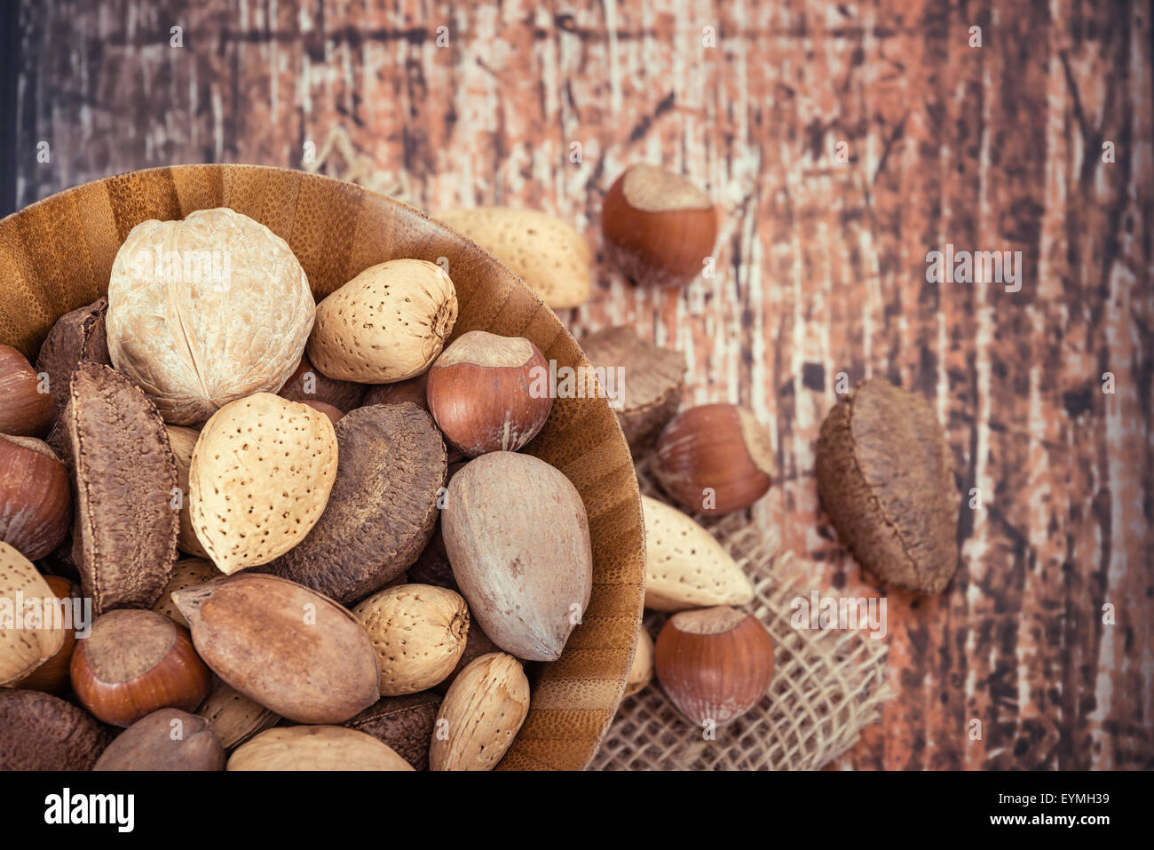 Mischen Sie Muttern mit Mandeln, Walnüsse, Haselnüsse, Pekannüsse und Paranüsse in einer Holzschale rustikalen Hintergrund. Ansicht von oben. Stockfoto