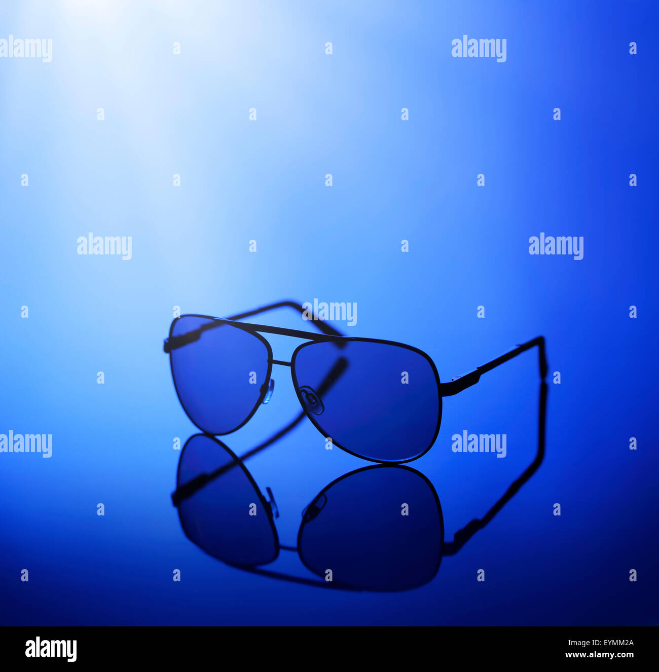 Sonnenbrillen in blaues Licht auf einem reflektierenden Hintergrund. Stockfoto