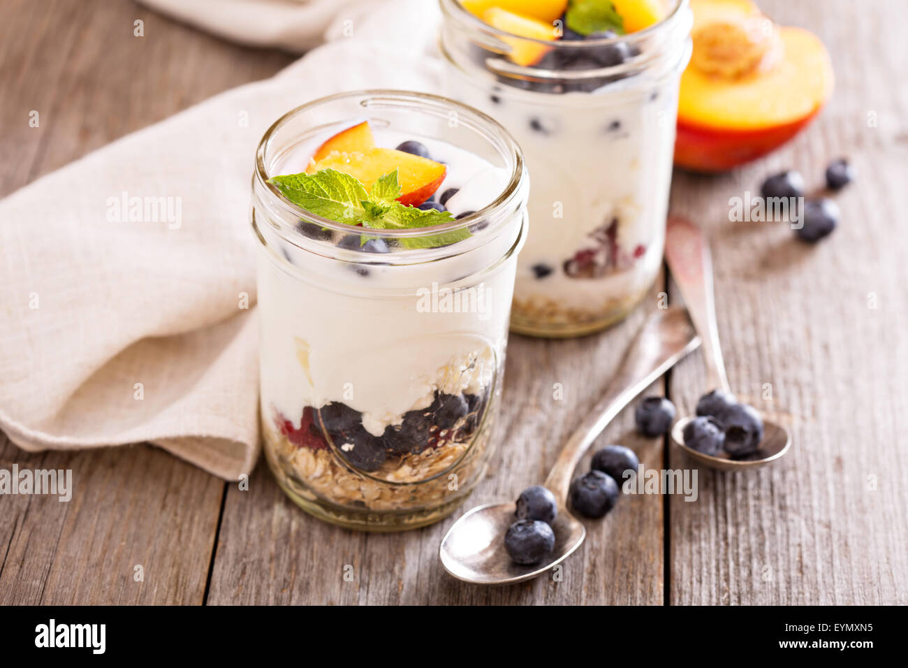 Geschichtete Frühstück Parfait mit Müsli, Pfirsiche oder Beeren Stockfoto