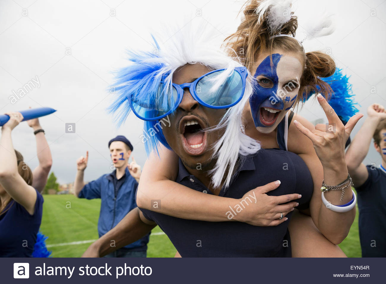 Porträt begeisterte Fans in blau huckepack und feiern Stockfoto