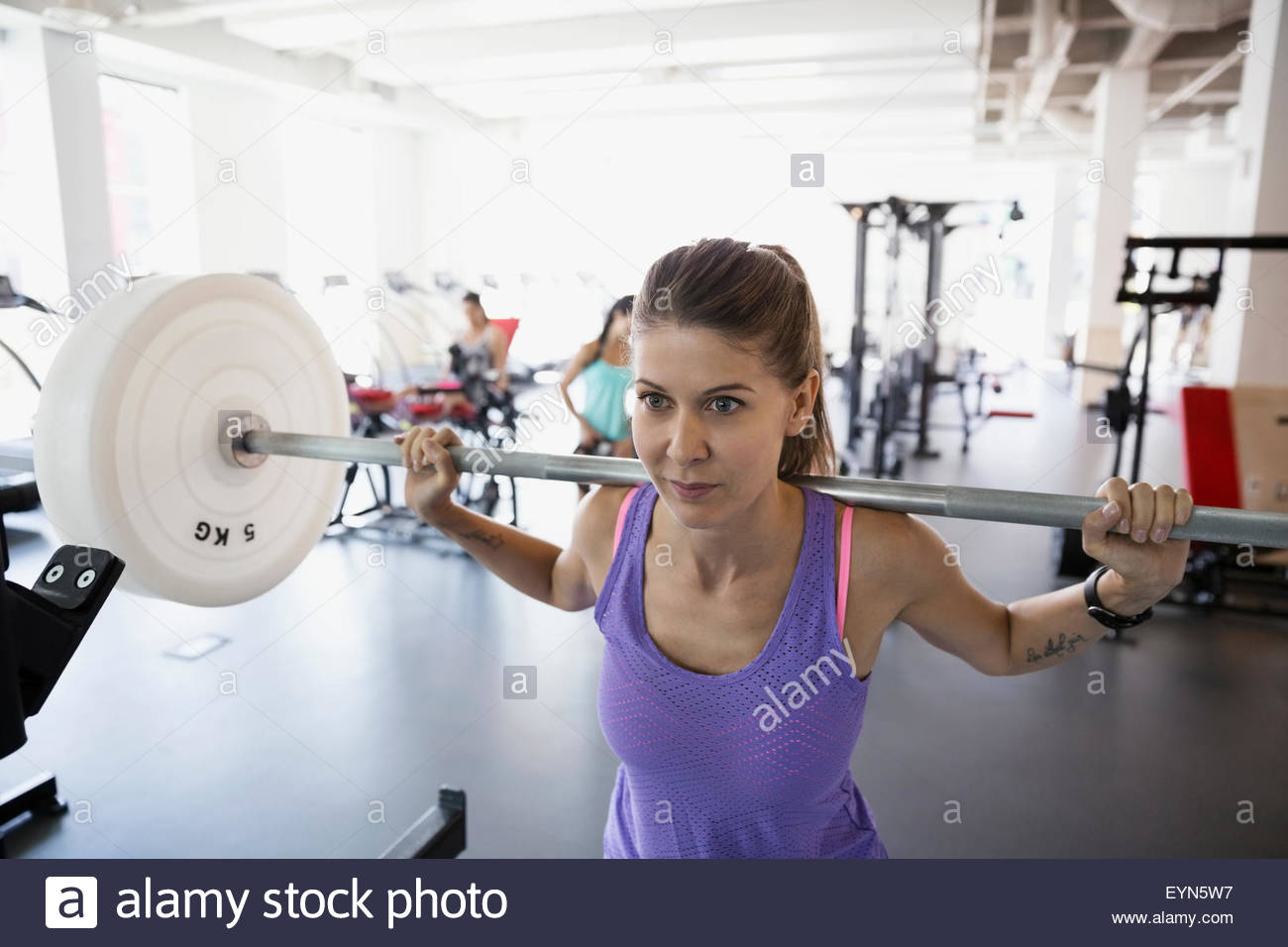 Entschlossenen Frau macht Kniebeugen im Fitnessstudio Stockfoto