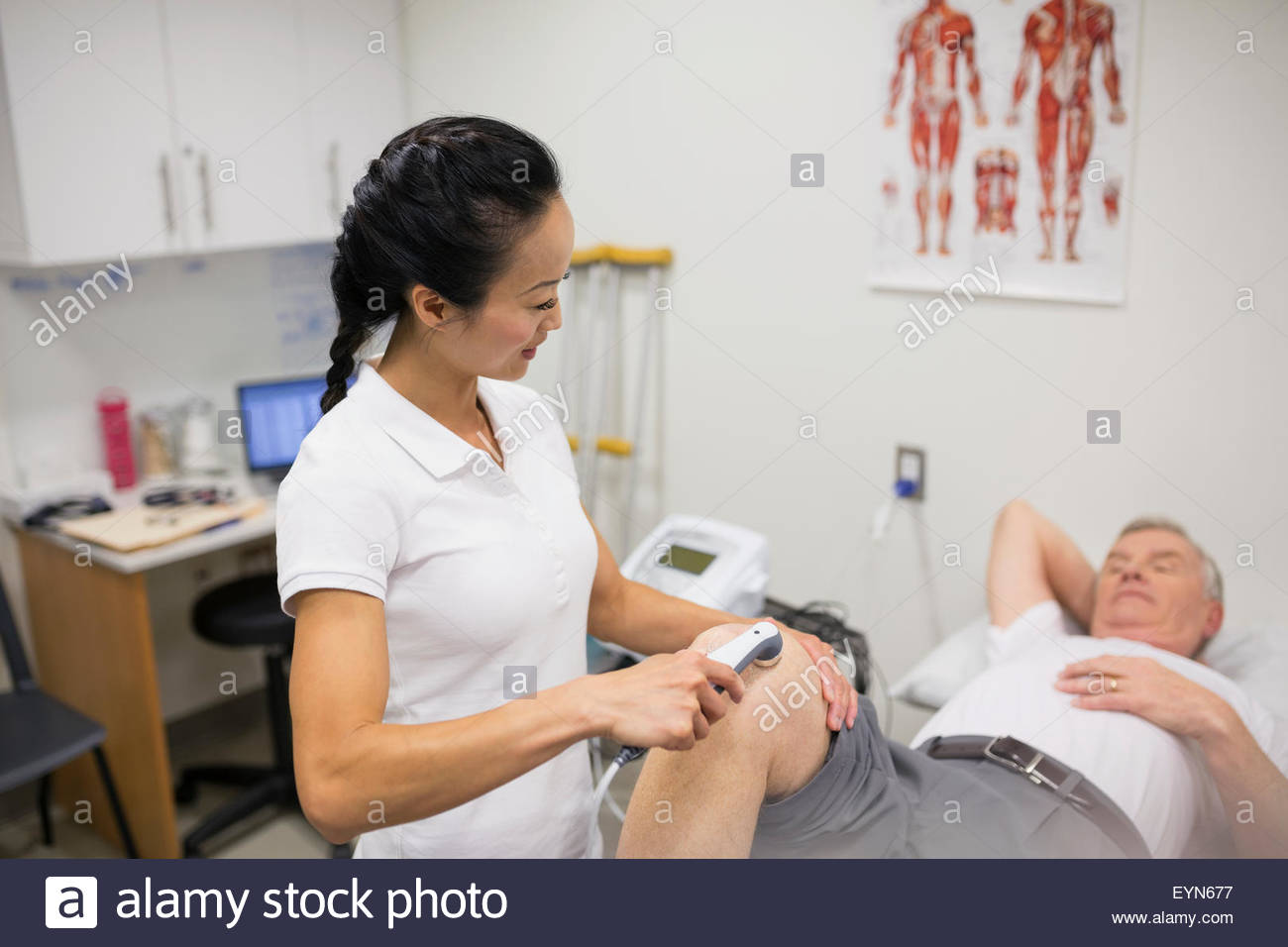 Physiotherapeut mit Ultraschallsonde auf Patienten Knie Stockfoto