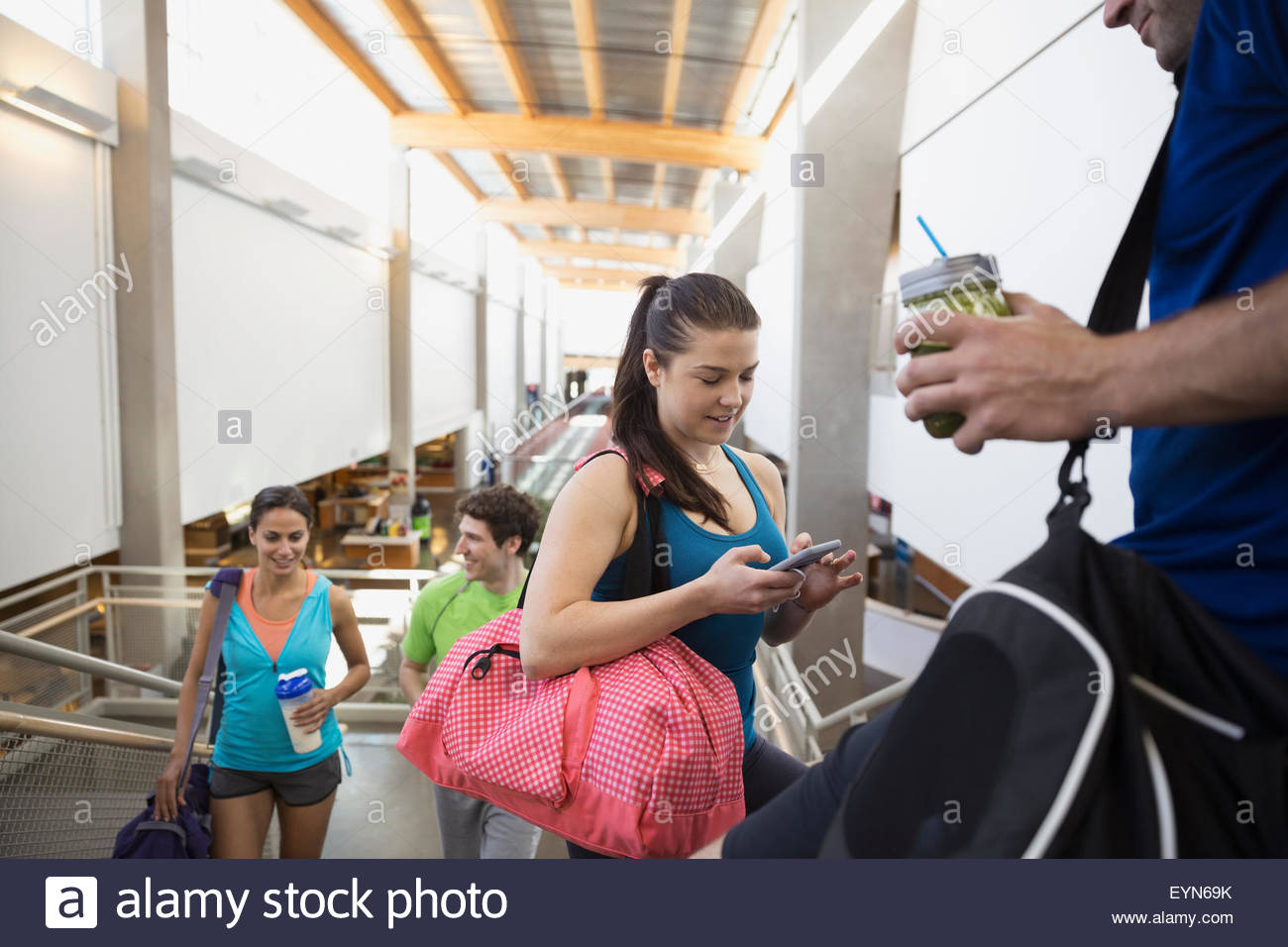 Freunde sprechen und mit Handy in Turnhalle Stockfoto