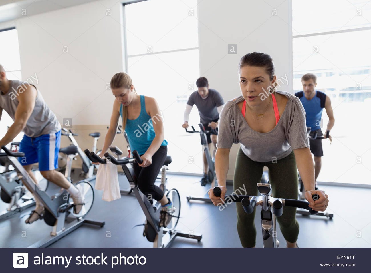 Spin-Klasse auf stationären Fahrrädern in Turnhalle Stockfoto