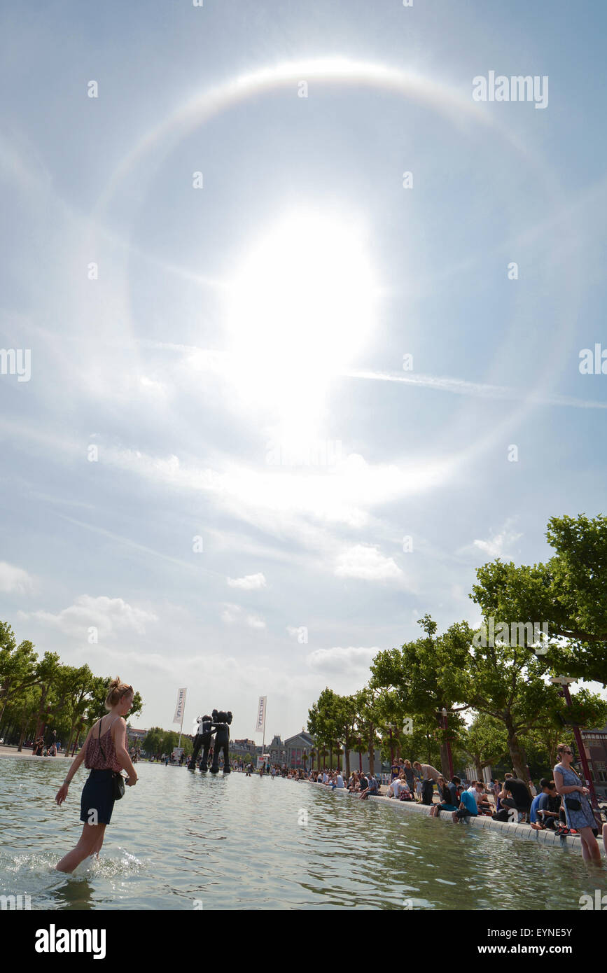 Eine Sonne-Halo-Phänomen sieht man über den Pool und KAWS Skulptur auf dem Museumplein Platz, Amsterdam Niederlande am 16. Juli 2015 Stockfoto