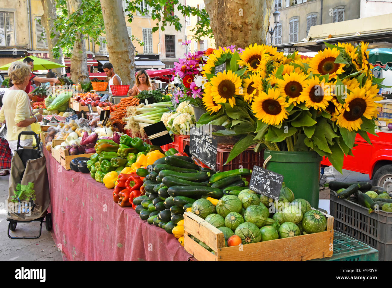 Sonnenblumen und Gemüse zum Verkauf auf dem französischen Marktstand im Stadtzentrum von Aix en Provence, Provence, Südfrankreich Stockfoto