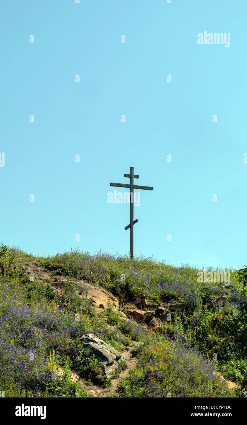 Große alte hölzerne orthodoxe Kreuz auf einem Hügel an einem klaren, blauen wolkenlosen Himmel an einem Sommertag Stockfoto