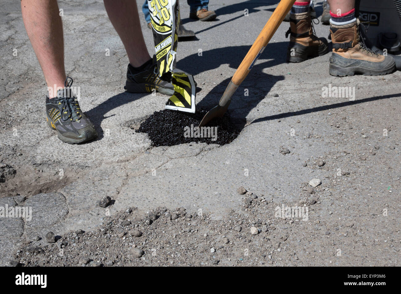 Hamtramck, Michigan - Mitglieder die Hamtramck Guerilla Straßenreparatur Besatzung Füllung Schlaglöcher auf den Straßen der Stadt. Stockfoto