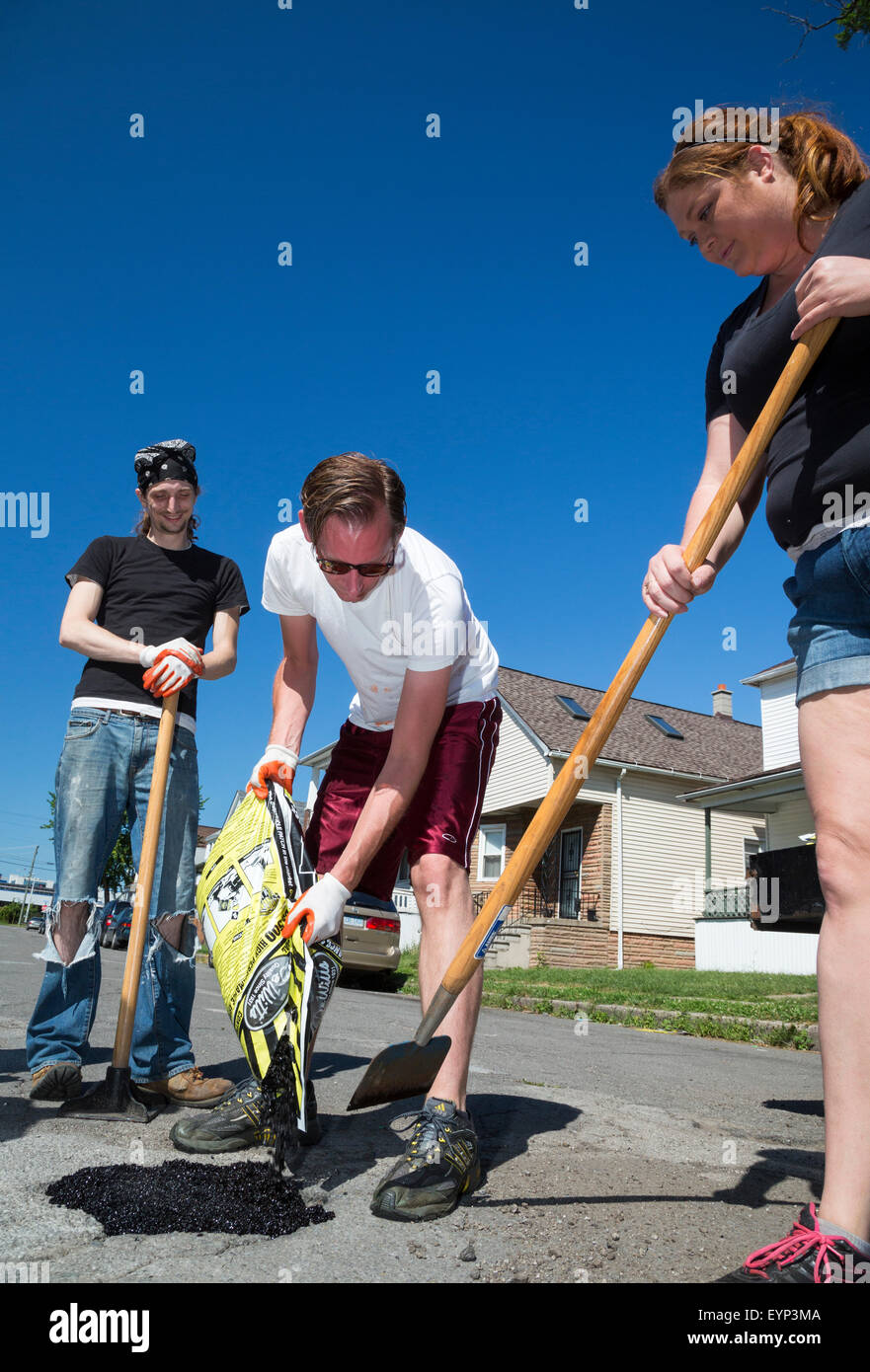Hamtramck, Michigan - Mitglieder die Hamtramck Guerilla Straßenreparatur Besatzung Füllung Schlaglöcher auf den Straßen der Stadt. Stockfoto