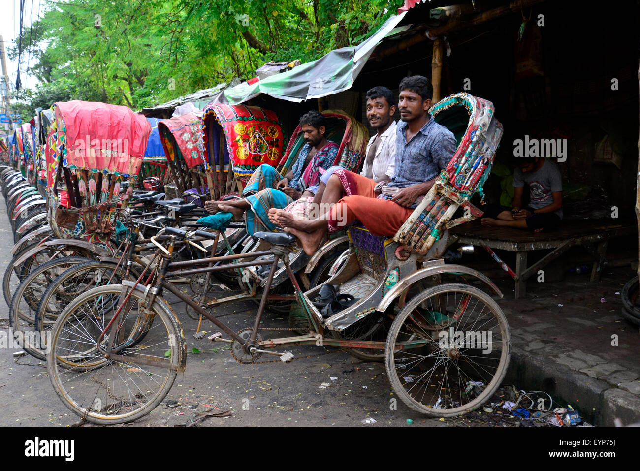 Bangladeshi Rikschafahrer warten auf Fahrgäste in Dhaka. Bangladesch. Am Juli 2015 migrieren Tausende von Menschen aus dem Land in die Hauptstadt Dhaka als Rikscha-Fahrer zu arbeiten, da sie keine Arbeit in ihren Dörfern während der drei-bis sechsmonatigen Monsun-Saison haben. Jede Rikschafahrer verdienen oft weniger als US$ 4 pro Tag. Stockfoto