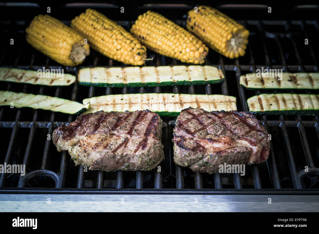 Rib-Eye Steak mit Zucchini und Mais auf Gas-Grill, soft-Fokus Stockfoto