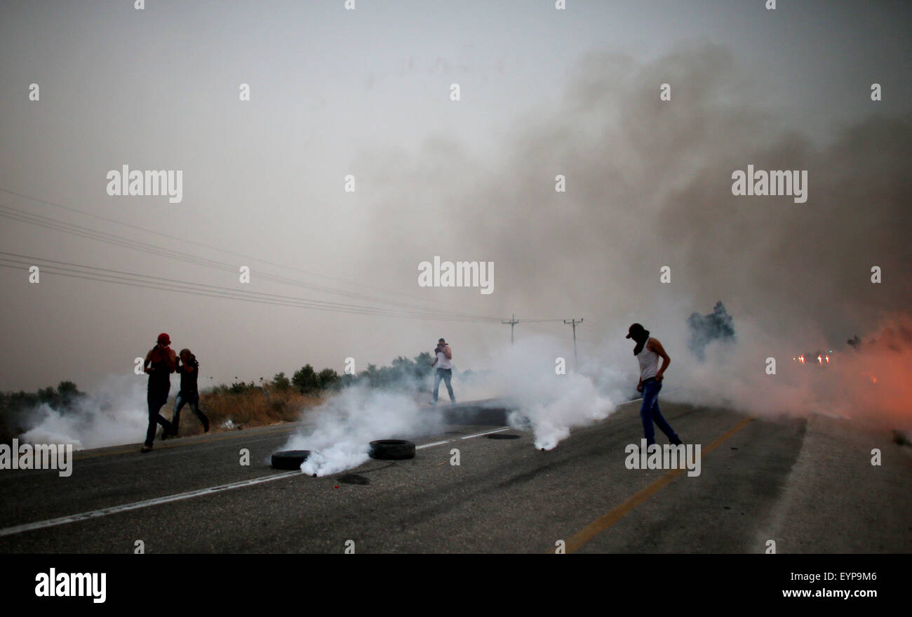 Duma, Westjordanland, Palästinensische Gebiete. 2. August 2015. Palästinensische Demonstranten laufen für die Abdeckung von Tränengas abgefeuert von israelischen Sicherheitskräften bei Zusammenstößen auf einer Straße der führenden Duma Dorf, am 2. August 2015, nach einer Demonstration in Reaktion auf den Tod eines palästinensischen Kleinkindes in einem Brandanschlag von jüdischen Siedlern im Westjordanland verbrannt. Juli 31 Brandanschlag in Duma, die auch kritisch des Kleinkindes Eltern und Bruder verwundet, geschürt laufenden Spannungen zwischen Israelis und Palästinensern, löst Proteste von Hunderten von Menschen und sporadische Zusammenstöße (Credit-Bild: © Ahmad Stockfoto