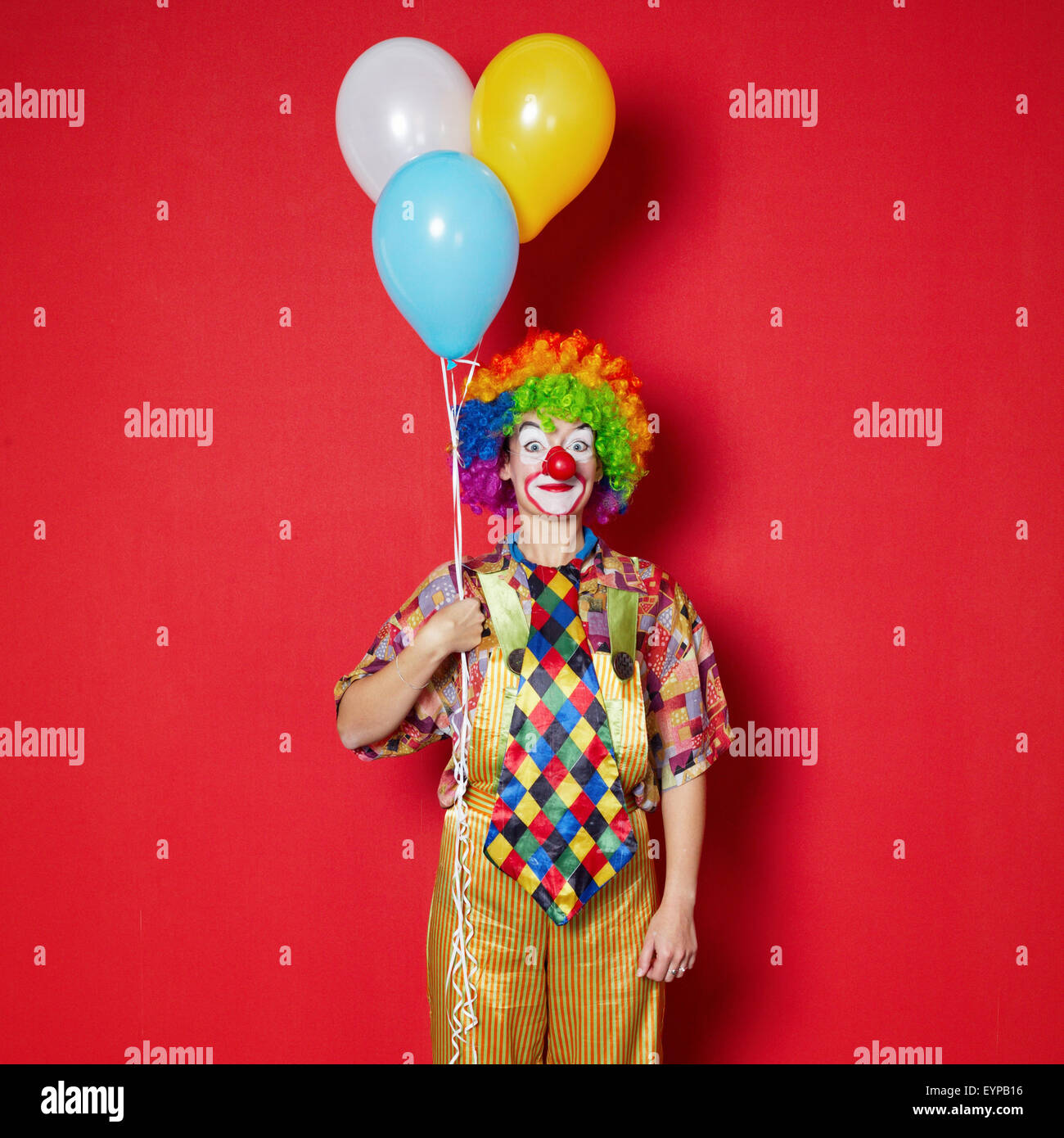 Clown mit Luftballons auf rotem Grund Stockfotografie - Alamy