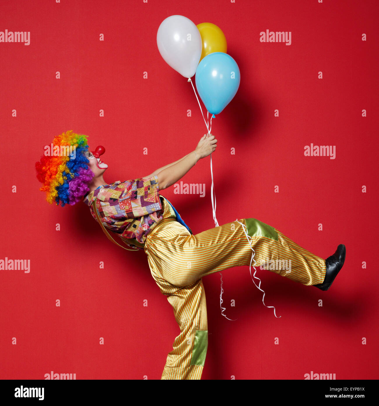 Clown mit Luftballons auf rotem Grund Stockfotografie - Alamy