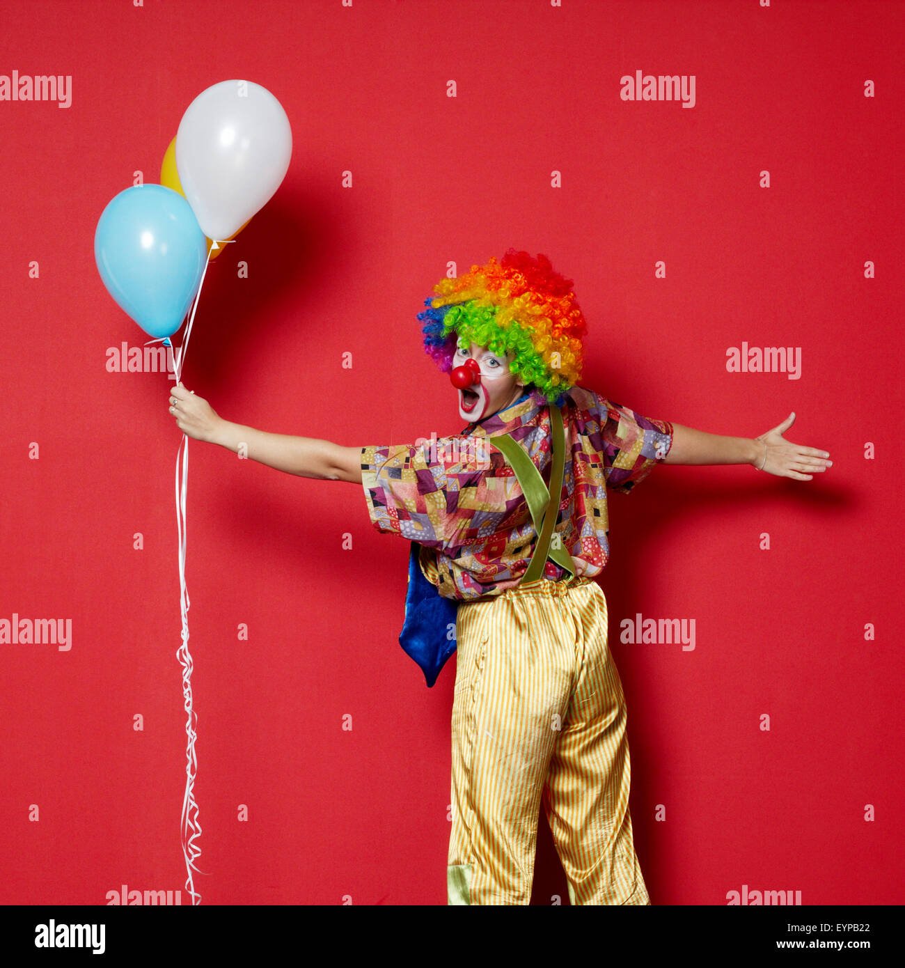 Clown mit Luftballons auf rotem Grund Stockfoto