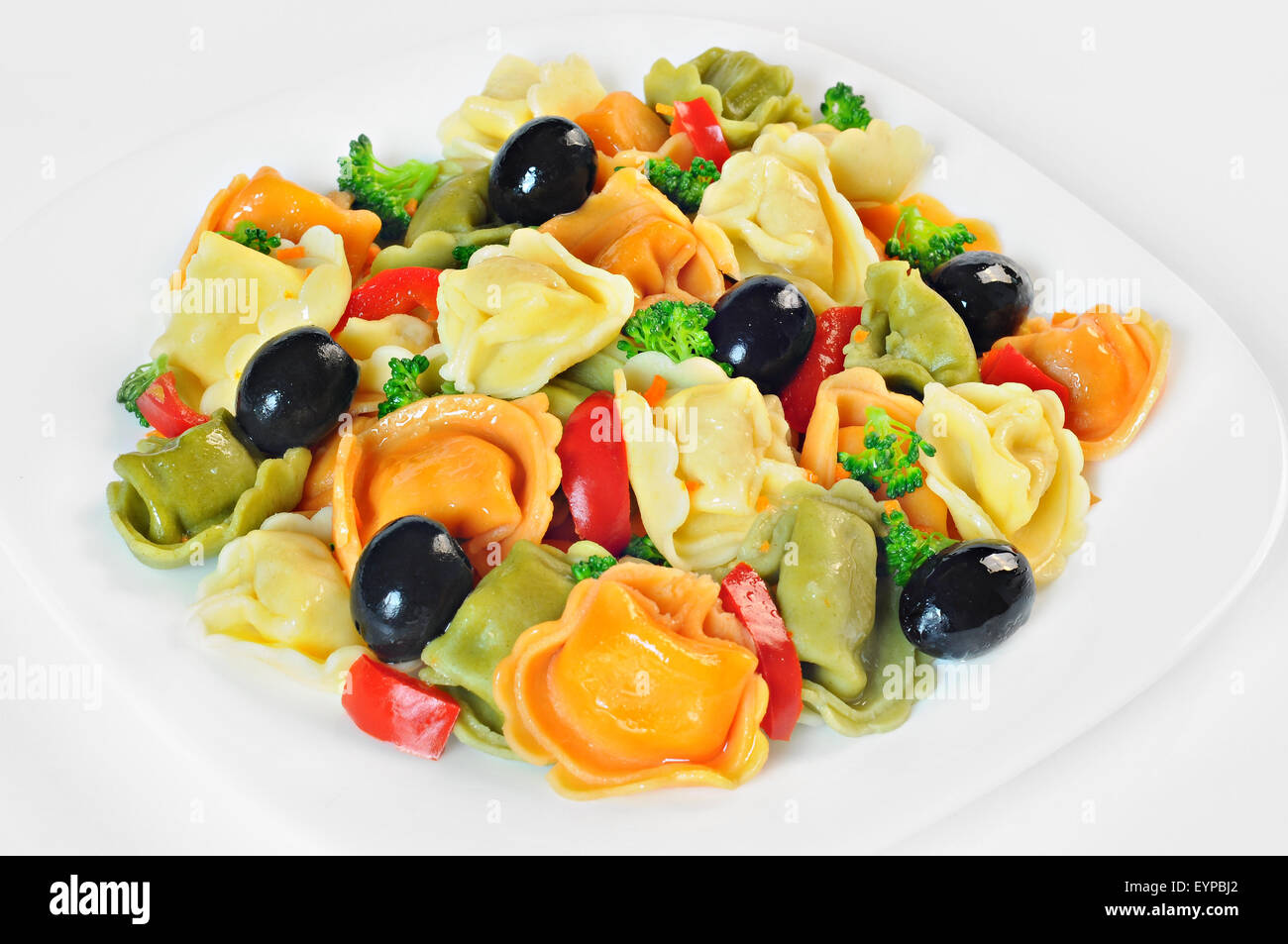 Salat mit Tortellini, Oliven, Brokkoli, rote Paprika, auf einem Teller, weiß-Hintergrund Stockfoto