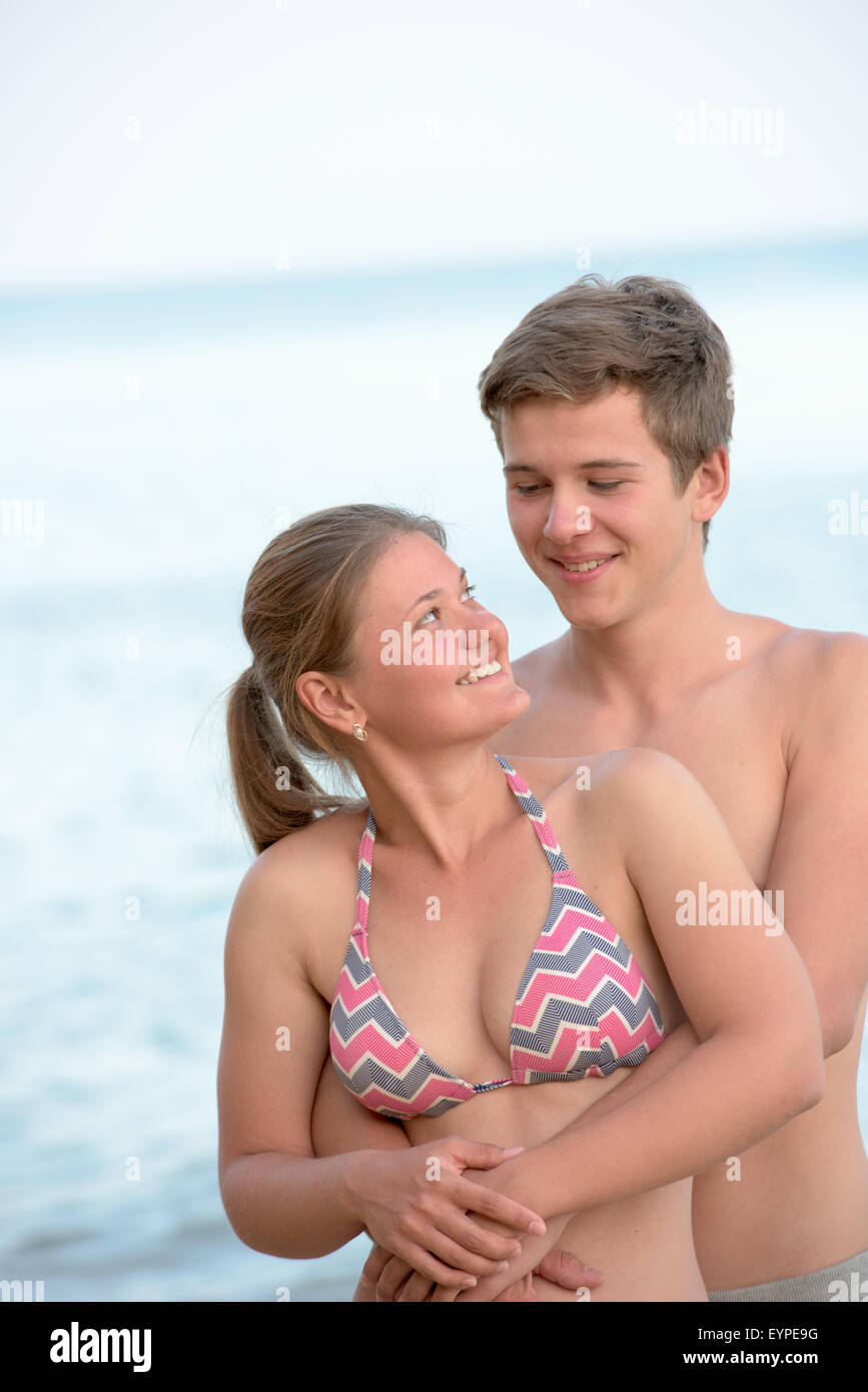 Junge Frau und Mann umarmt, auf der Suche zueinander und lächelnd Stockfoto